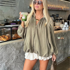 Close view of draped fabric and lantern sleeve shape on a zip jacket