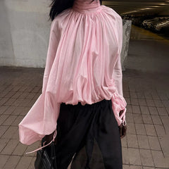 Close-up of pleated sheer texture and high neckline finish