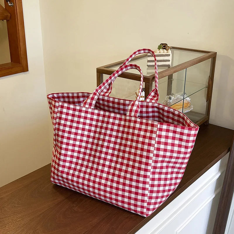 Oversized red-and-white plaid canvas tote bag on wooden table