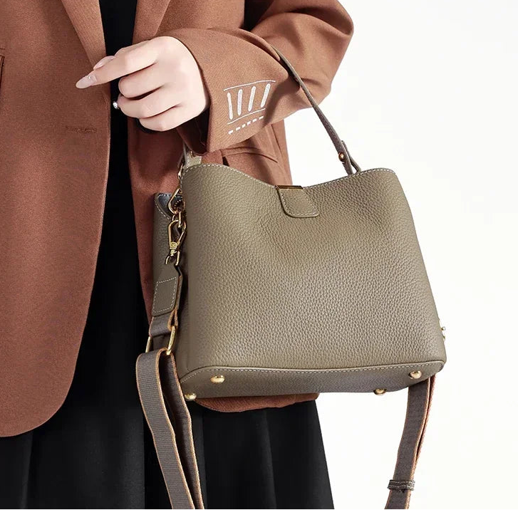 Leather handbag worn crossbody with streamlined design and zip top