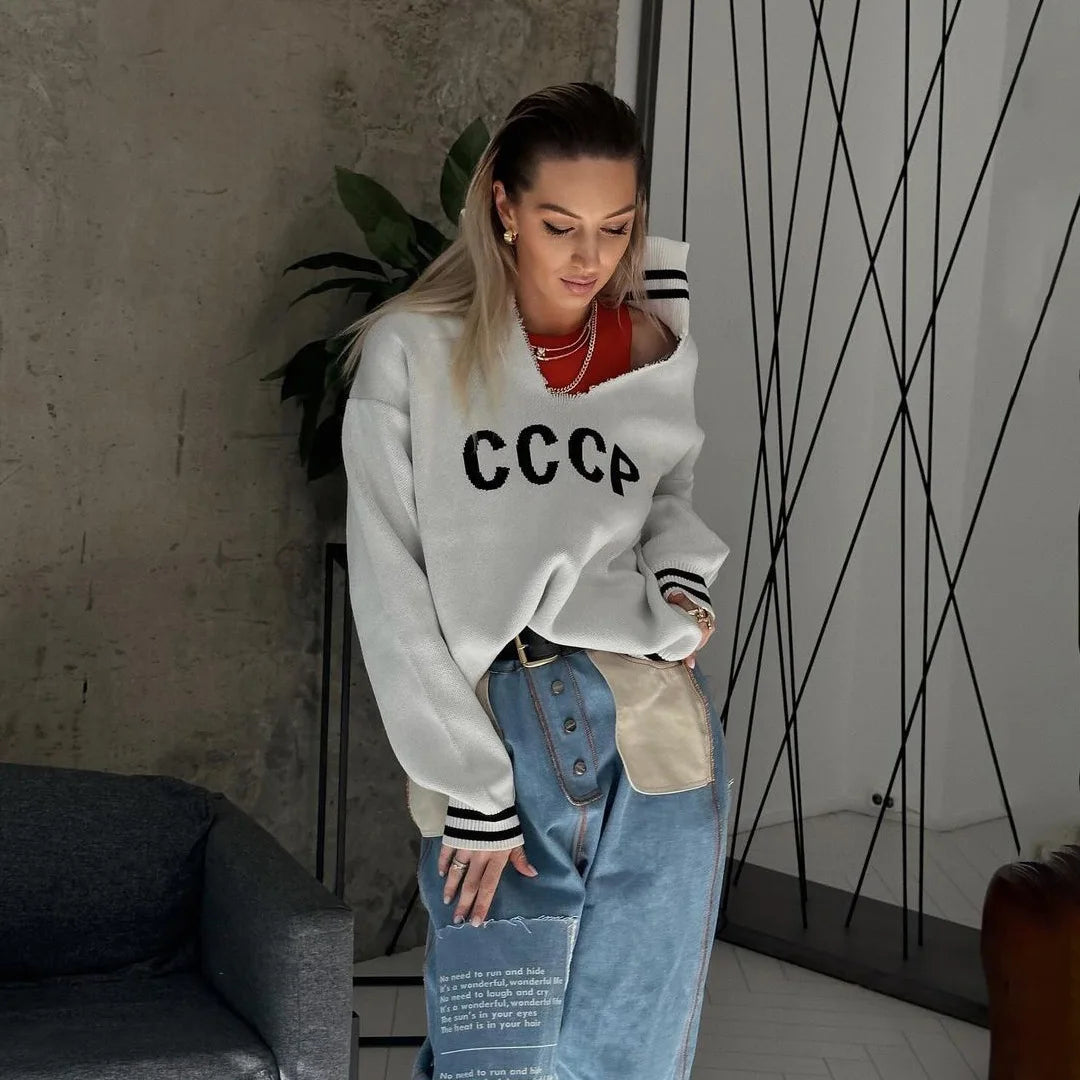 A woman wearing a letter-embroidered batwing sleeve sweater.