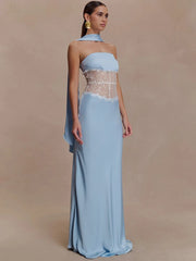 Full-length view highlights the scarf neckline, fitted bodice, and clean floor-length skirt on a light blue evening gown with minimal styling.