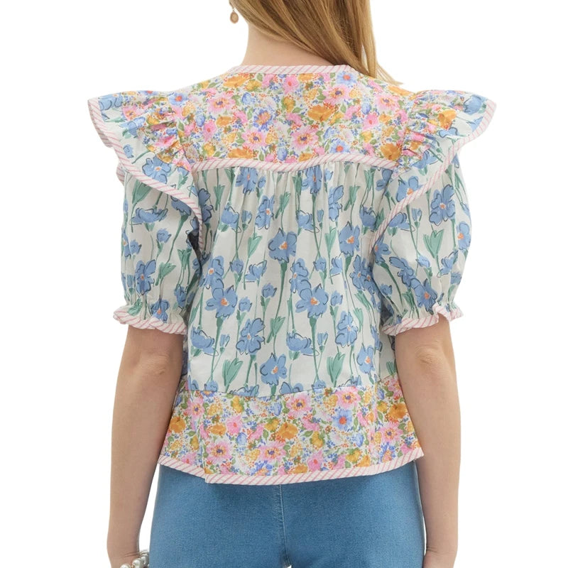 Styled outfit featuring floral V-neck blouse paired with denim