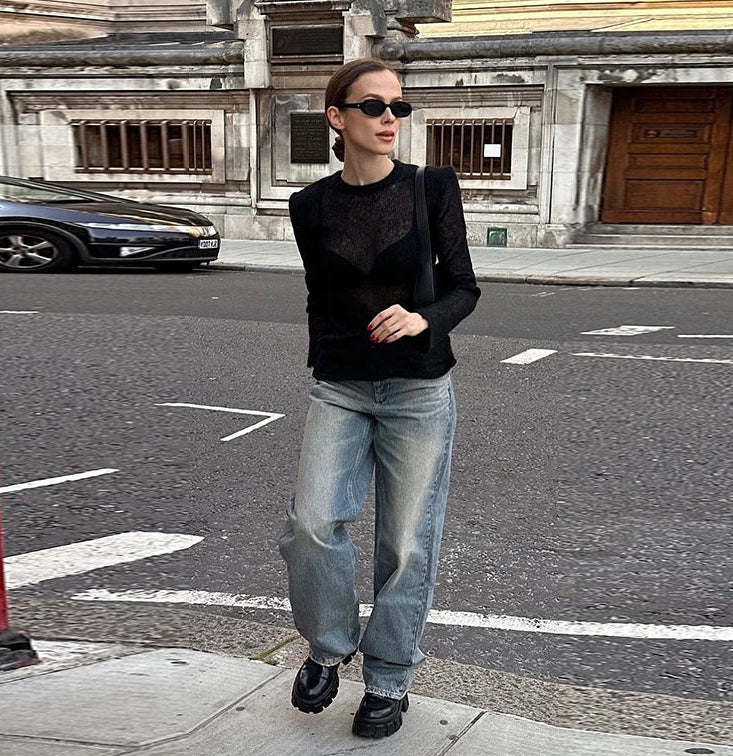 Detail view focusing on the knit transparency and smooth finish, capturing how the black sheer fabric looks in bright studio lighting.