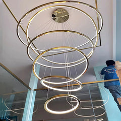 A close-up shot of the staircase chandelier, showing the sleek, contemporary design.