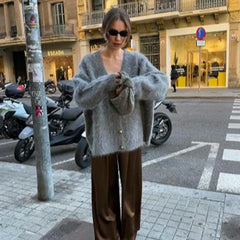 Full-body styling shot of a gray fluffy cardigan layered over a light top, capturing the regular length and cozy texture in natural outdoor light.