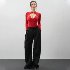 woman wearing a red long sleeve keyhole bodysuit with wide leg trousers