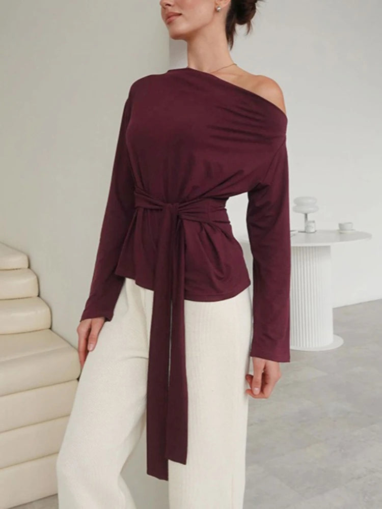 Close view highlighting the slash neckline and adjustable tie-up detailing across the waist.