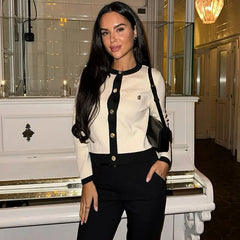Woman in a standing in an elegant interior setting loose fit junior black white cardigan shown in outdoor setting 