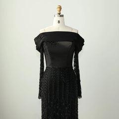 Black off-shoulder luxury trumpet formal gown with crystal and sequin embellishments on a mannequin against a plain background