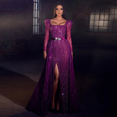 A woman modeling a fuchsia mermaid gown with a dramatic overskirt.