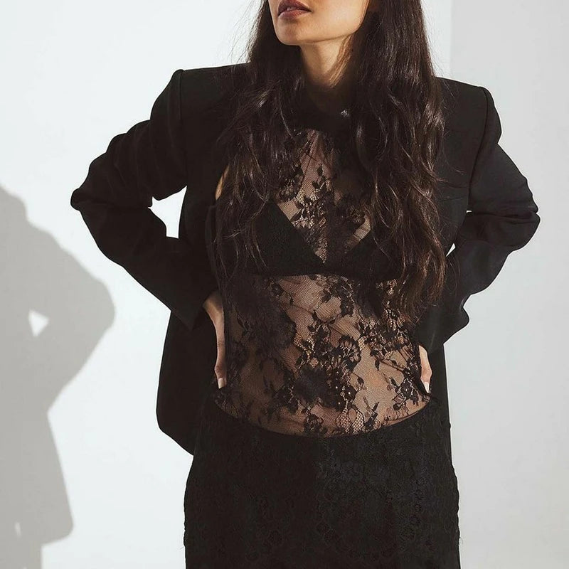 Sheer lace top styled with black trousers for an elevated evening look