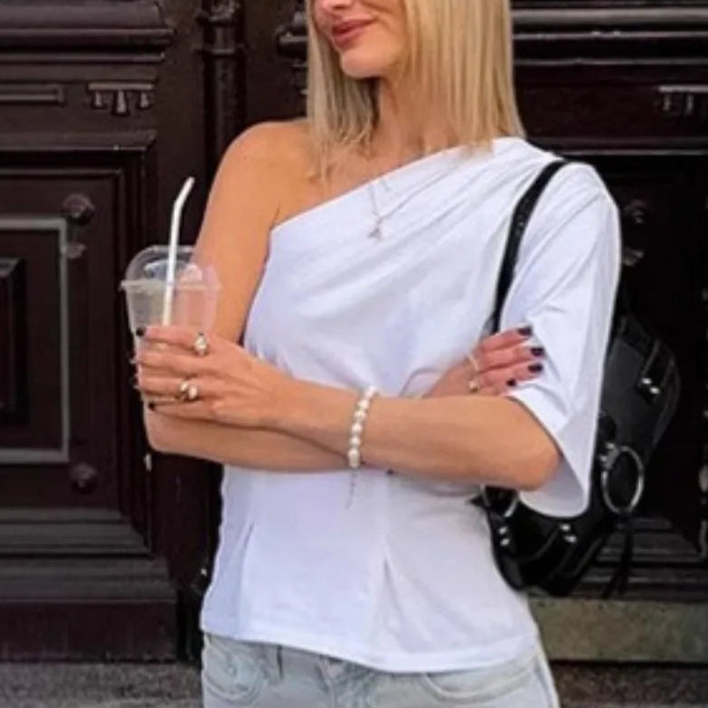 Asymmetric white top worn with jeans for minimalist outfit