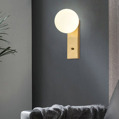 A  Frosted Glass Ball LED Metal Wall Sconce Light Fixtures in White and Gold colours, beside a bed.