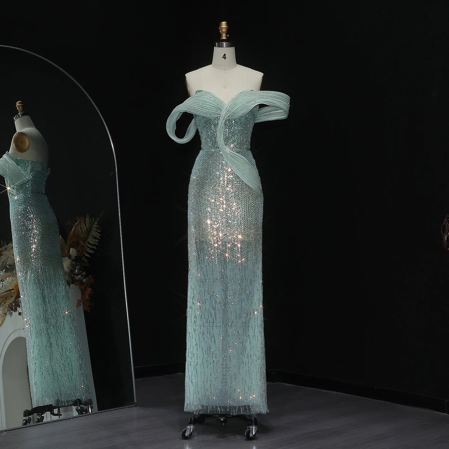 Teal evening gown on a mannequin against a black background