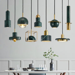 A collection of modern pendant lights with marble and copper finishes, some with a gold color, suspended from the ceiling. Hanging overa a dining table.