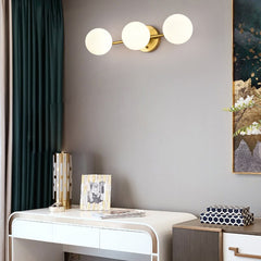 A  Frosted Glass Ball LED Metal Wall Sconce Light Fixtures in white and gold colours, over a reading table.