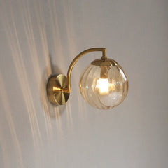 A modern transparent yellow lighted  LED colour glass pendant light fixture mounted on a wall.