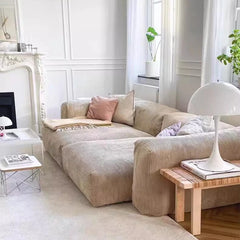 “Modern lounge couch placed in living room with white curtains and coffee table”

