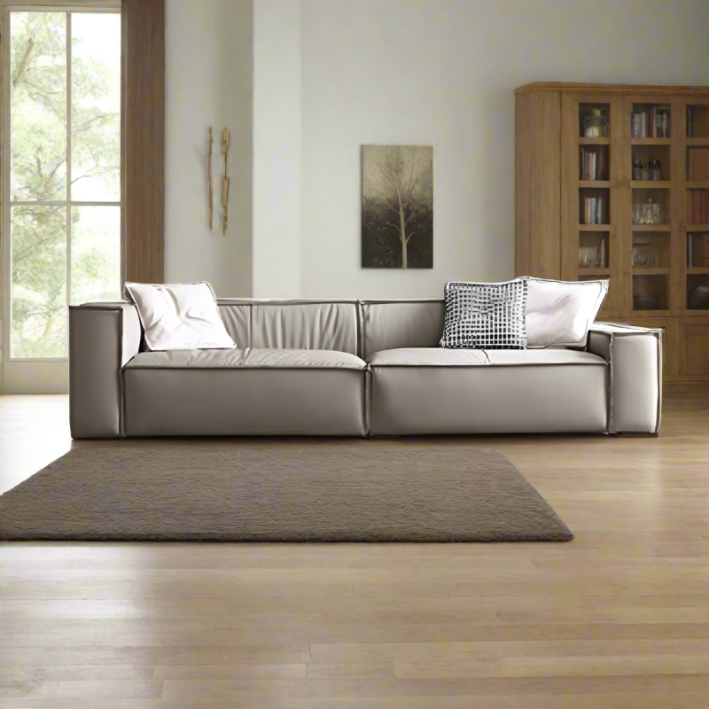 Modern design wooden frame leather sofa with a metal accent, displayed in a bright living room setting.