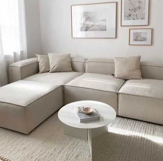 A beige modular combination porter sectional sofa with multiple cushions, displayed in a bright and spacious room.