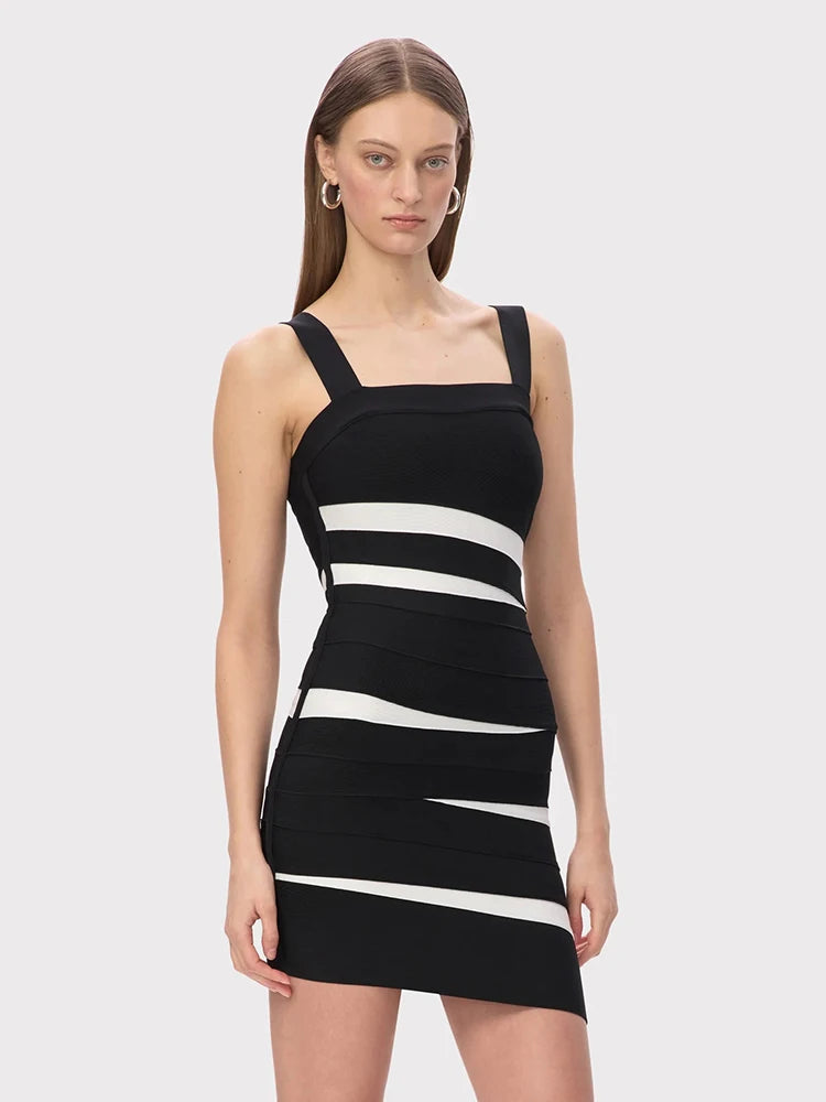 Close-up of the dress’s patchwork paneling and contrasting stripe placement, showing the structured bandage knit and smooth, sculpted finish.