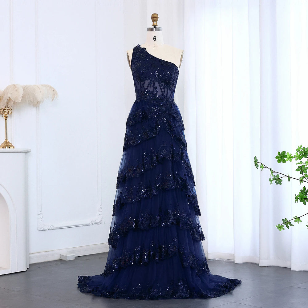 Full-length view of a floor-length one-shoulder prom gown with tiers