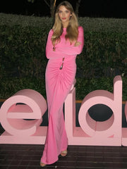Editorial shot of navy long-sleeve evening dress styled in an outdoor setting