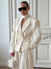 Neutral patchwork blazer styled with wide-leg pants and a clutch