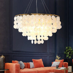 Nordic shell disc chandelier with gold ring over dark paneled living room