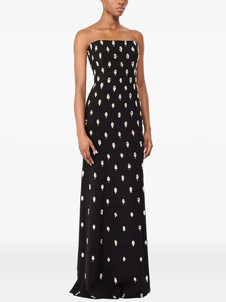 Close-up of the embellished texture across the dress, showing repeated motif detailing and a smooth base fabric with a refined finish.