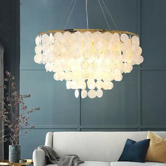 Capiz shell flush mount chandelier above a low-profile sofa