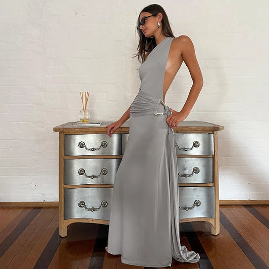 A woman wearing a one-shoulder bandage maxi dress with a metal ring.