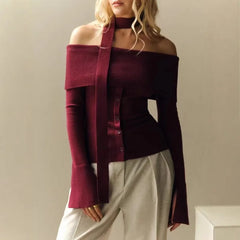 A woman wearing an one-shoulder scarf top with a unique, asymmetric design.

