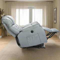 Side view of a grey reclined adjustable electric power recliner lift sofa chair with framed painting, and well-lit big windows on one side.