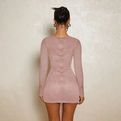 Person wearing a pink lace dress against a plain background