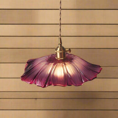 A pendant LED light fixture with a pink glass shade and a knob switch, mounted on a wall with striped wooden wall on the  back ground.