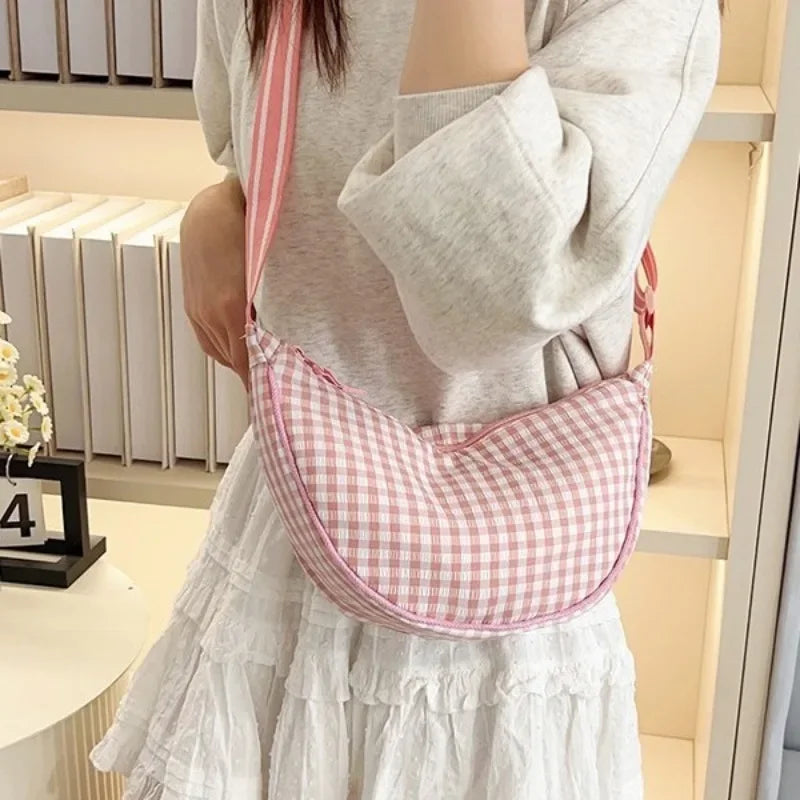 Pink gingham plaid hobo bag worn over the shoulder indoors