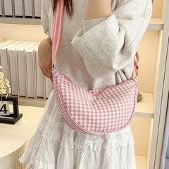Pink gingham plaid hobo bag worn over the shoulder indoors
