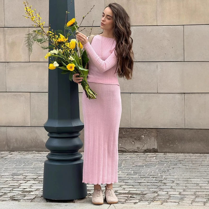 Woman in pastel pink knit sweater and ribbed skirt set outdoors