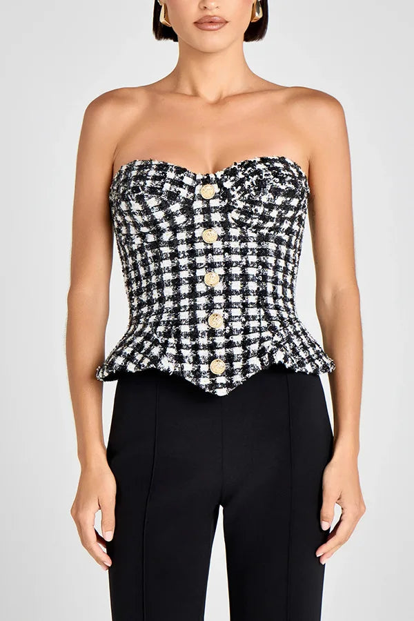 Close-up of the plaid tweed texture and button detailing, showing the tailored weave and structured bodice shaping.