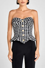 Close-up of the plaid tweed texture and button detailing, showing the tailored weave and structured bodice shaping.