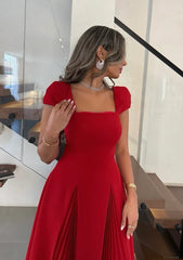 Full-length pleated A-line midi dress styled with pointed heels