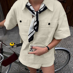 Close-up of chest pockets and button detail on beige short-sleeve shirt