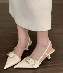 White pointed toe slingback sandals with buckle strap on wooden floor