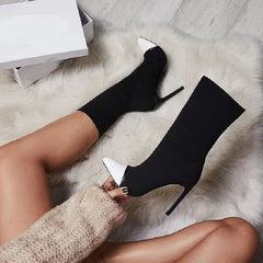 A side view of the stretch fabric boots showing the thin heel and pointed toe.