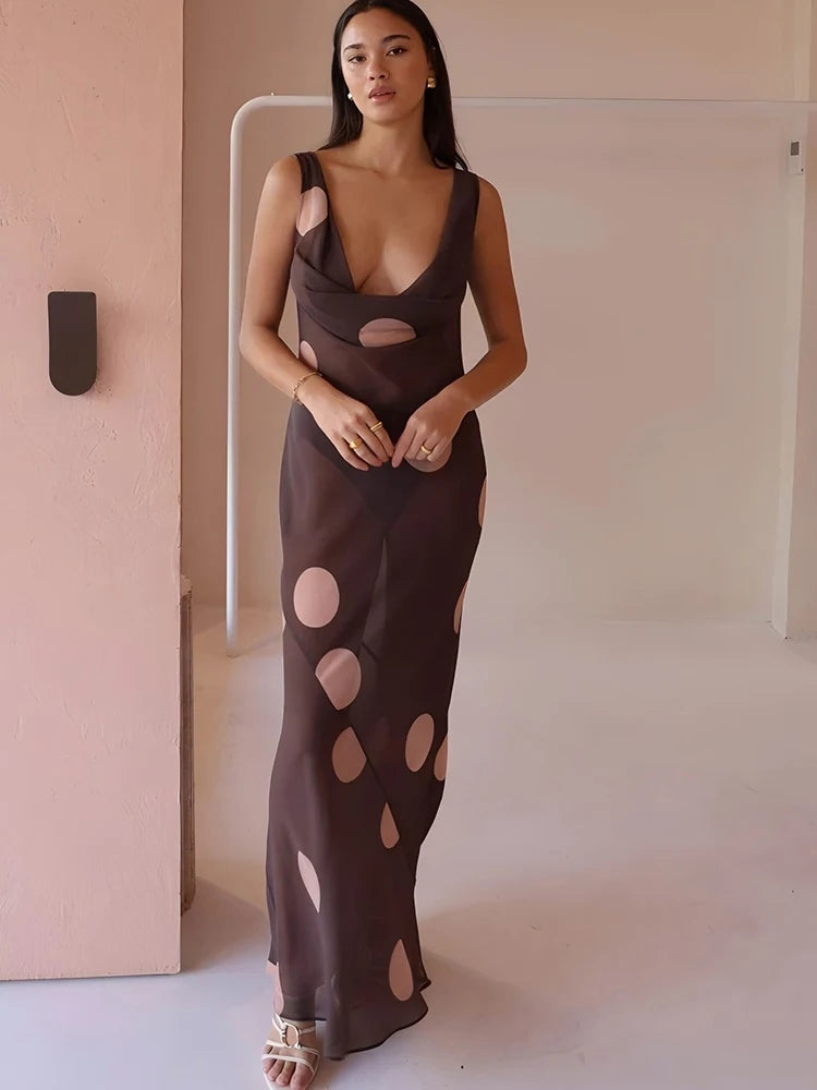 Woman wearing a brown dress with cut-out design in a minimal indoor setting