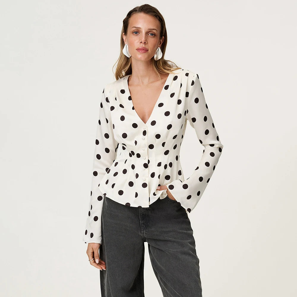 A woman modeling a polka dot V-neck long-sleeve T-shirt.