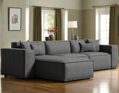 A grey modular combination porter sectional sofa with multiple cushions, displayed in a bright and spacious room photo frame and a reading lamp.