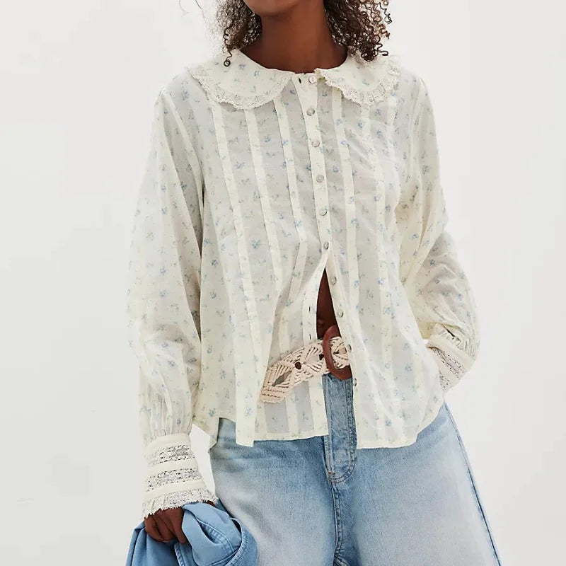 Model wearing a white printed Peter Pan collar blouse styled with denim, photographed against a clean studio background.